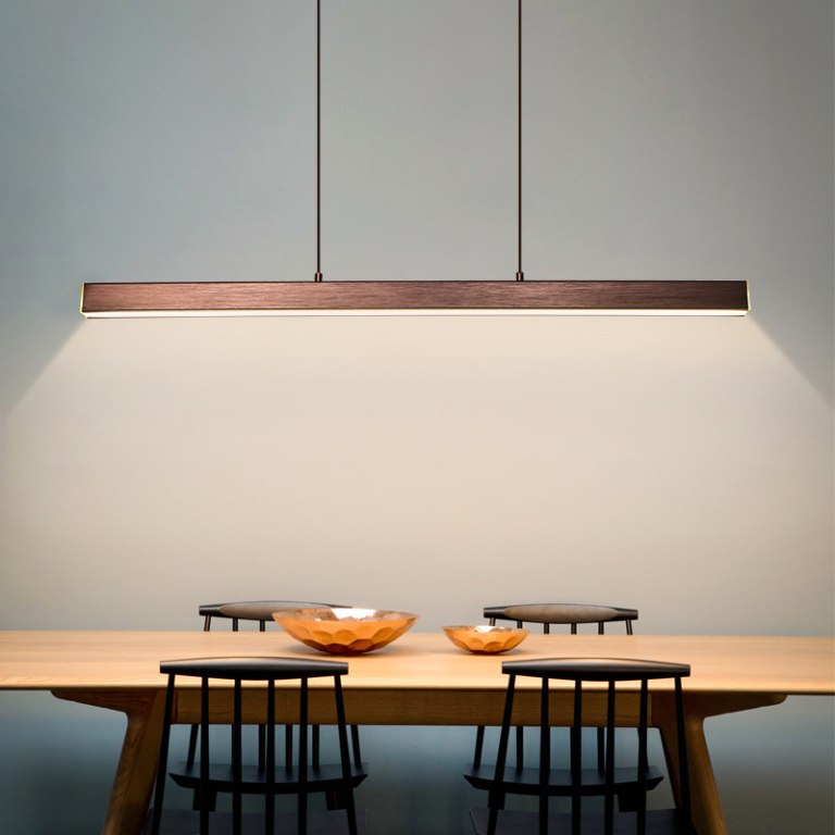 Black aluminum LED pendant light bar above a wooden dining table