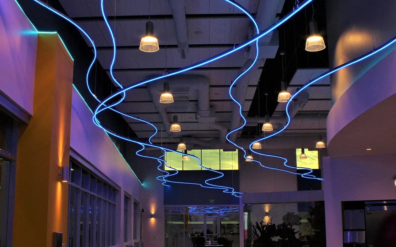 Blue LED neon flex lines across the ceiling of a commercial space