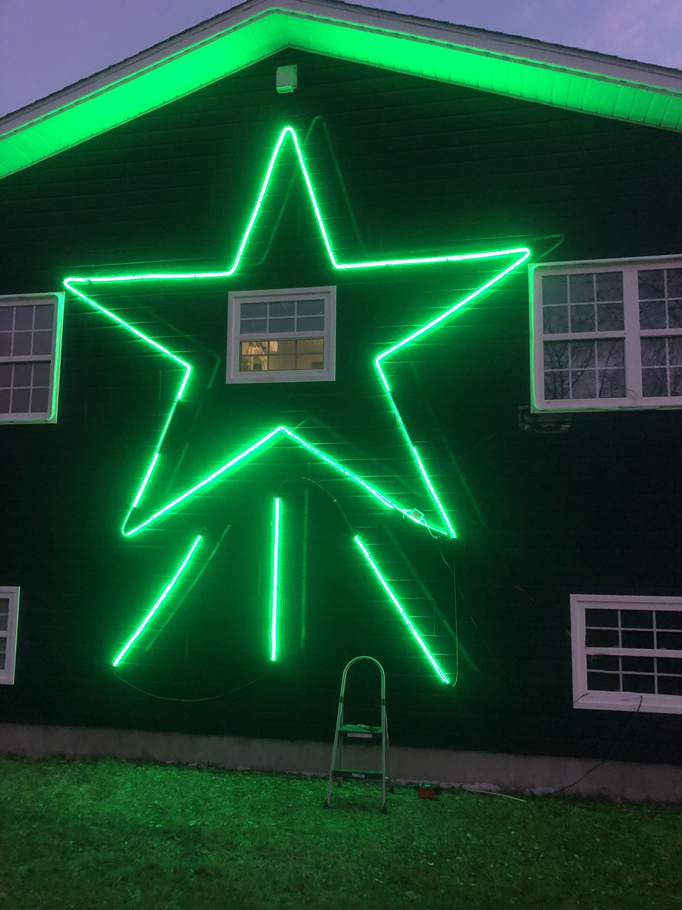 Green LED neon flex star shape on the side of a house
