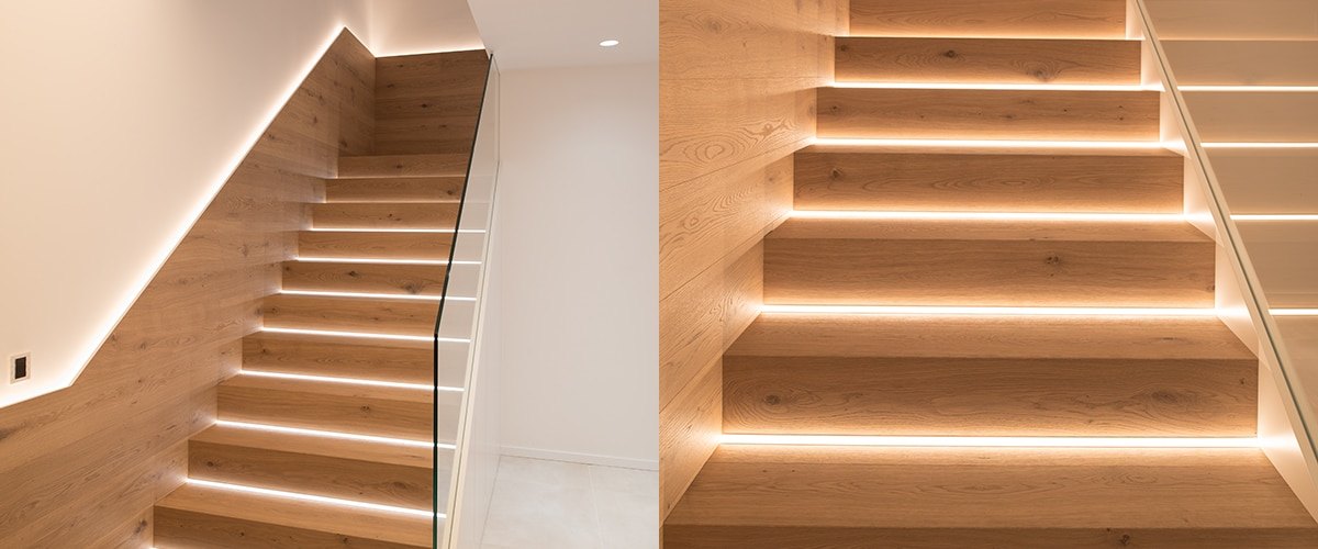 LED stair lights on an open staircase with a white wall