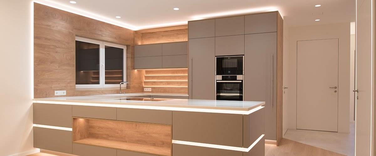 Warm LED strip lighting in wooden kitchen cabinets and shelving