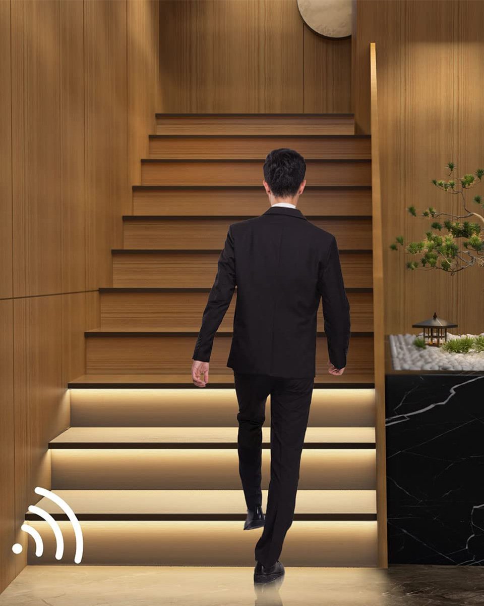 Motion-sensor LED stair lighting switching on step by step as a person walks up