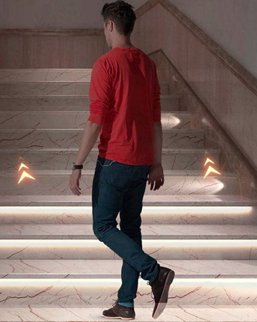 Motion-sensor LED stair lights: the lower treads light up one by one as a person walks up