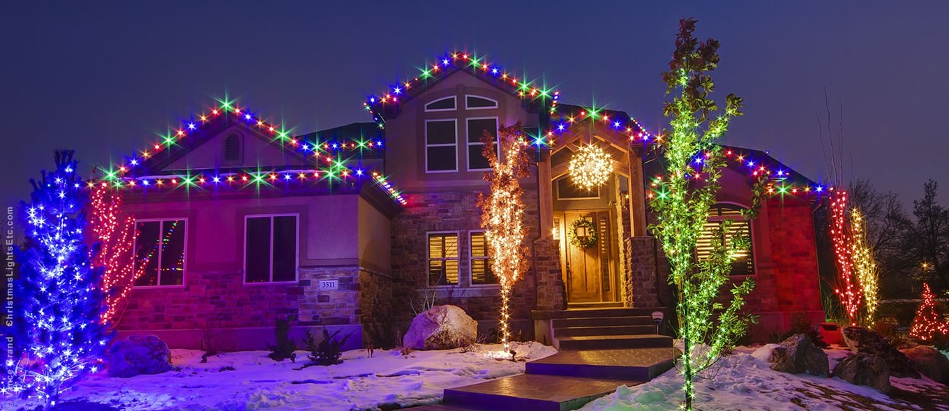 House with outdoor LED Christmas lights in the snow
