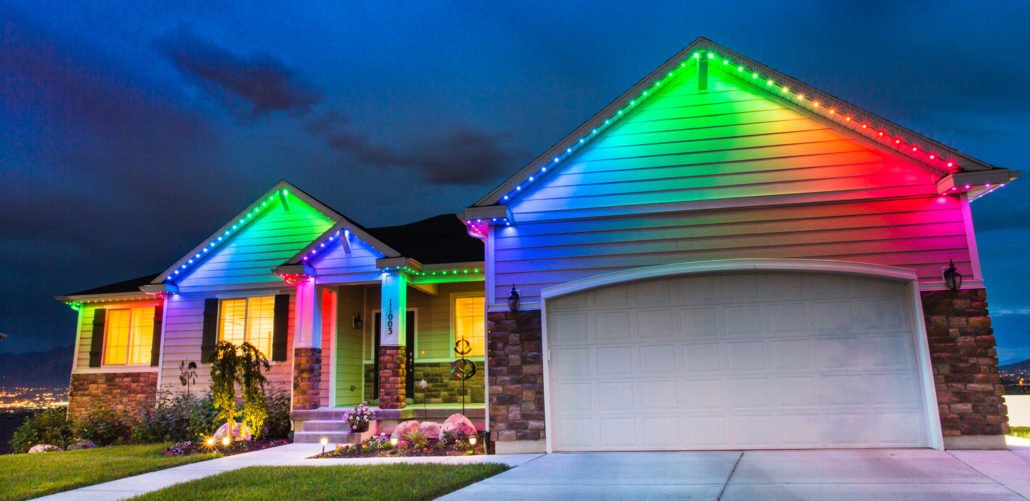 Permanent outdoor LED lights along the roofline of a family home in rainbow colours
