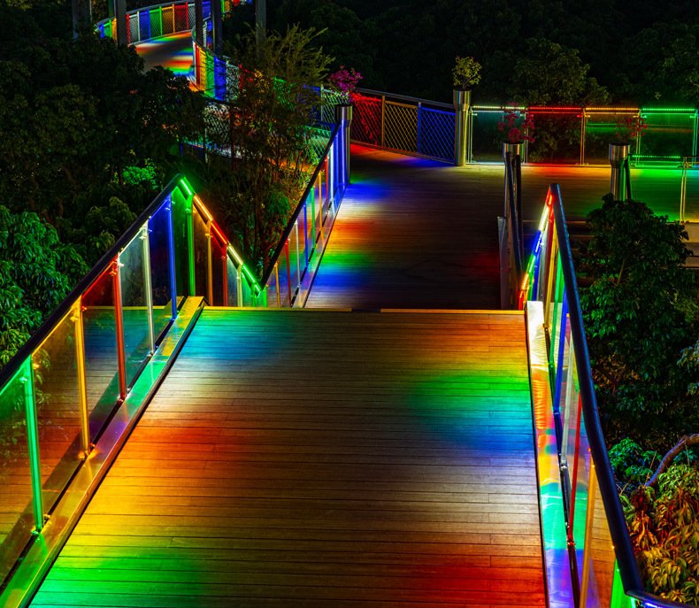 Wooden bridge walkway with colour-changing LED strip along the railings