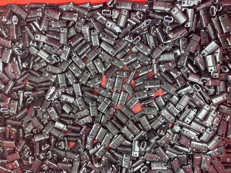 Bin of black LED strip connector housings drawn for one production run