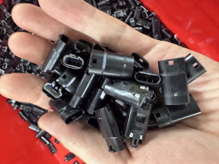 Male and female LED strip connector housings of the same series held in one hand