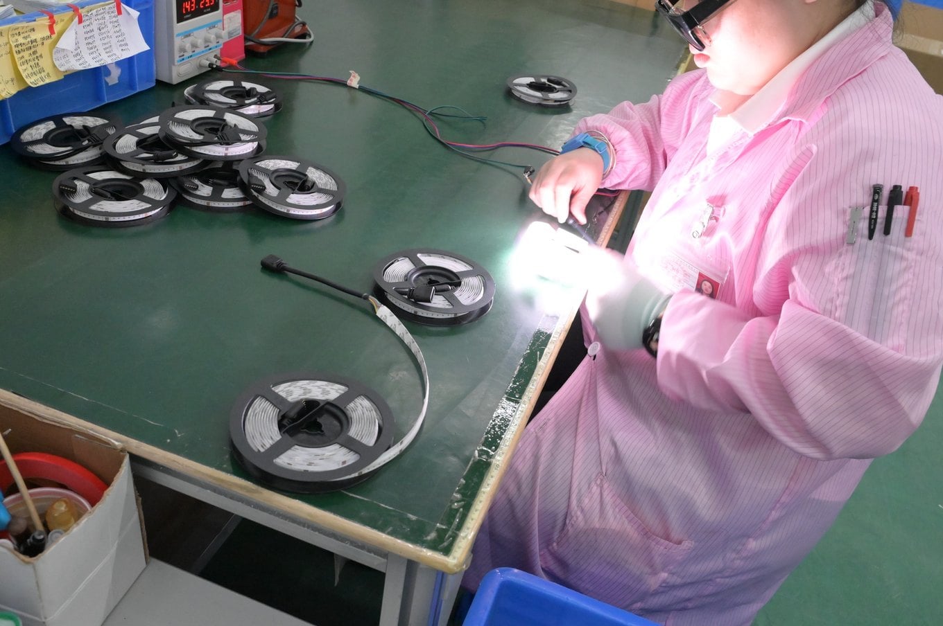 Technician bending and powering a finished LED strip reel